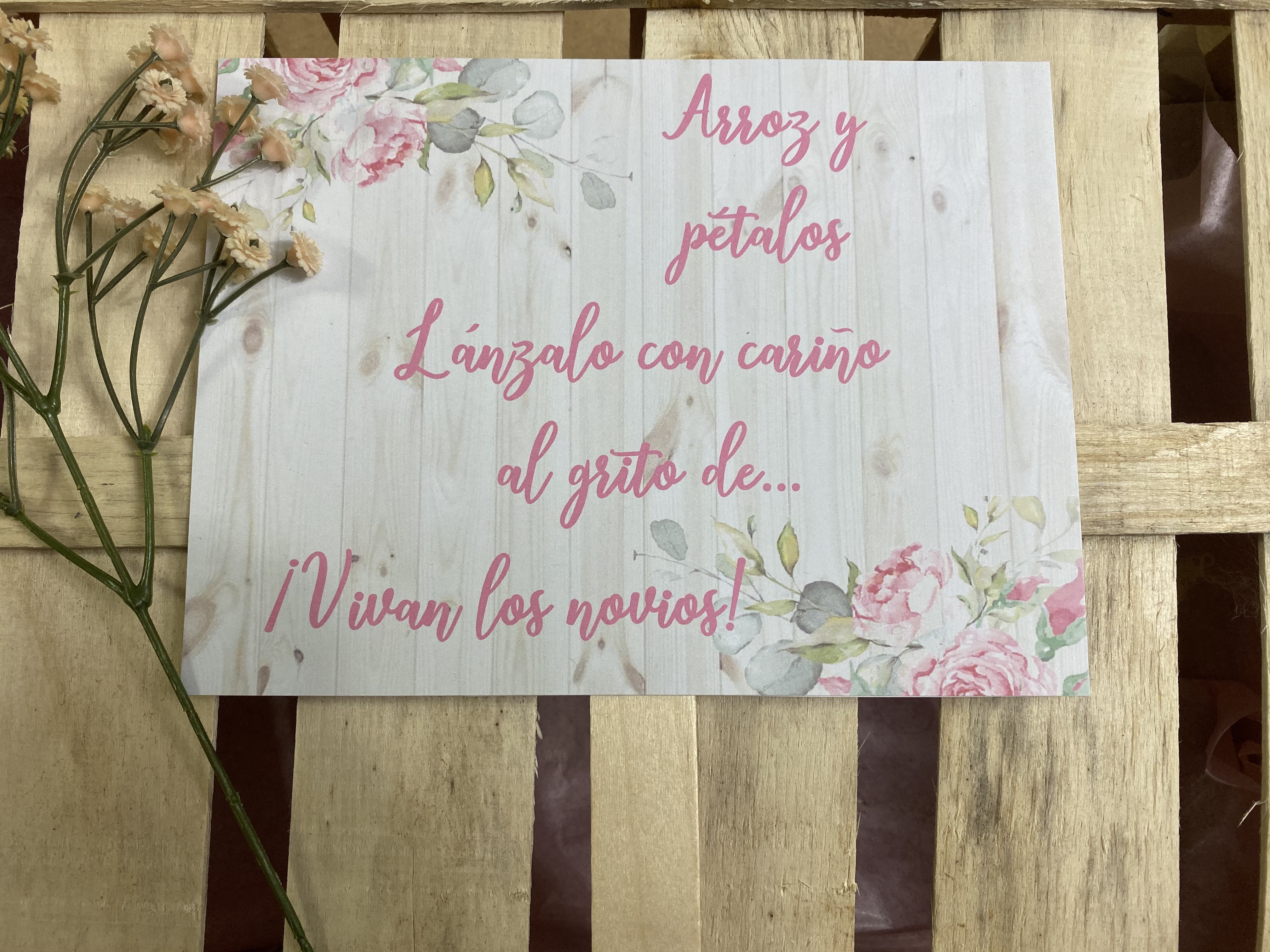 Cartel arroz y pétalos fondo madera con flores rosa claro y hojas