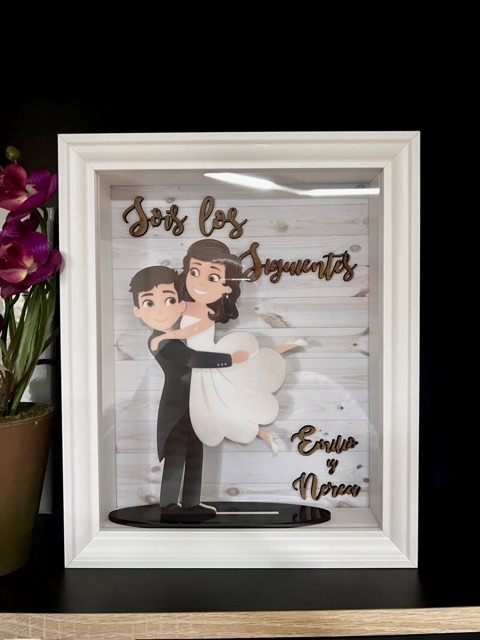 Novios en brazos en marco «sois los siguientes»